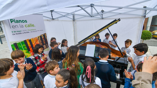 Escolares, alrededor de uno de los pianos instalados en Pozoblanco.
