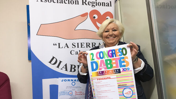 La presidenta de la Asociación Regional La Sierra, Toñi Ruiz, muestra el cartel del congreso