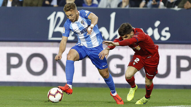 El rojillo Nacho Vidal intenta frenar la internada de Ontiveros, jugador del Málaga.
