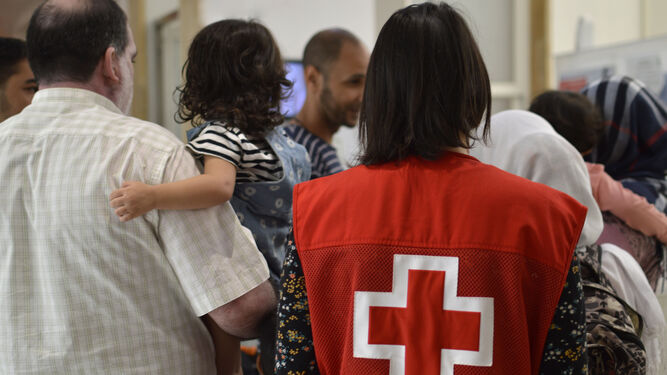 Una voluntaria de Cruz Roja atiende a una familia de refugiados