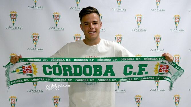 Samu González posa con la bufanda del Córdoba CF tras firmar su vuelta al club.