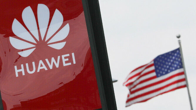 Un cartel de Huawei con la bandera de EEUU al fondo.