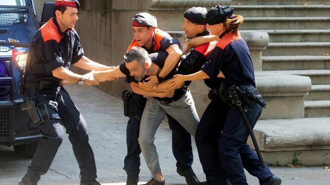 Cuatro 'mossos' reducen al tío de la víctima de violación que se abalanzó contra los acusados.