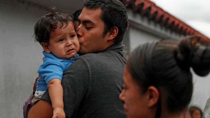 Un migrante guatemalteco recién deportado de EEUU besa a su hijo en Ciudad de Guatemala.