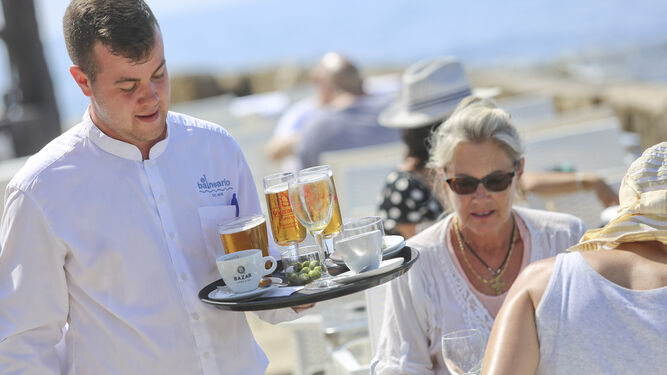 Un camarero sostiene una bandeja en una terraza de Málaga.