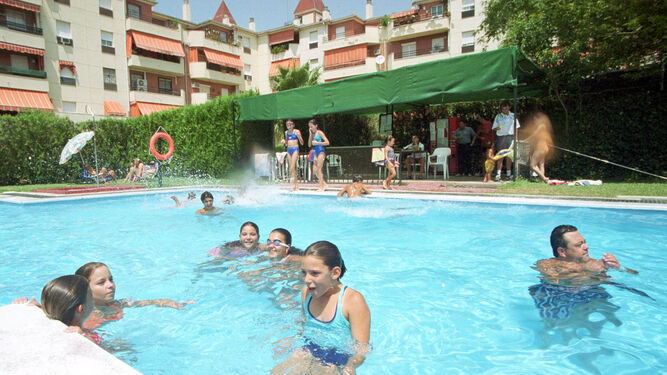 Unos jóvenes disfrutan en la piscina comunitaria.