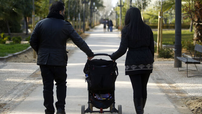 Una pareja pasea con su hijo.