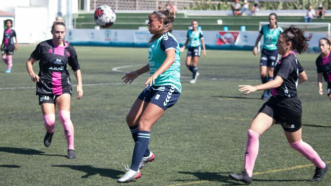 Una jugadora del Gran Canaria intenta controlar el balón entres dos jugadoras vallesanas.