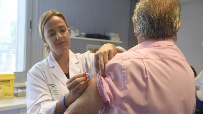 Una enfermera inyecta una vacuna contra la gripe a una persona mayor.