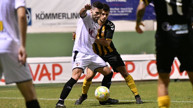 Un jugador del Pozoblanco protege el balón ante la presión de un rival del San Roque de Lepe.