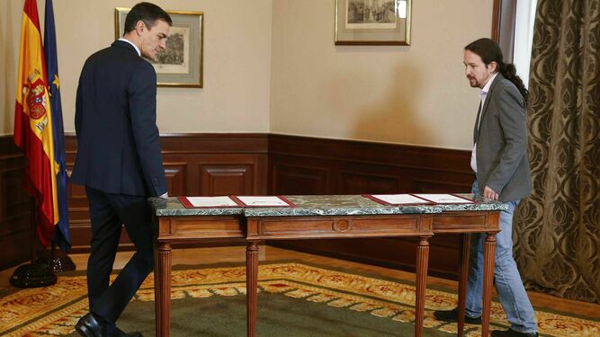El presidente del Gobierno en funciones, Pedro Sánchez, y el líder de Podemos, Pablo Iglesias, se disponen a firmar su preacuerdo de gobierno el pasado martes 12 de noviembre.