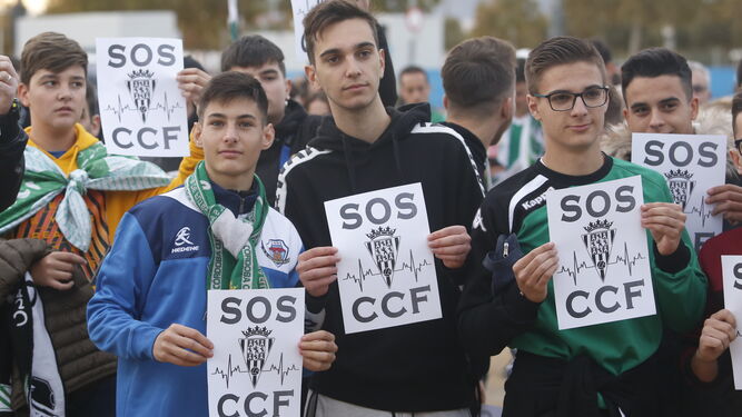 Aficionados del Córdoba CF muestran un mensaje de auxilio a las puertas de El Arcángel.