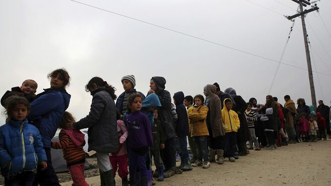Un grupo de refugiados haciendo cola para conseguir comida en un campamento provisional en Idomeni, en la frontera entre Grecia y Macedonia, en marzo de 2016.
