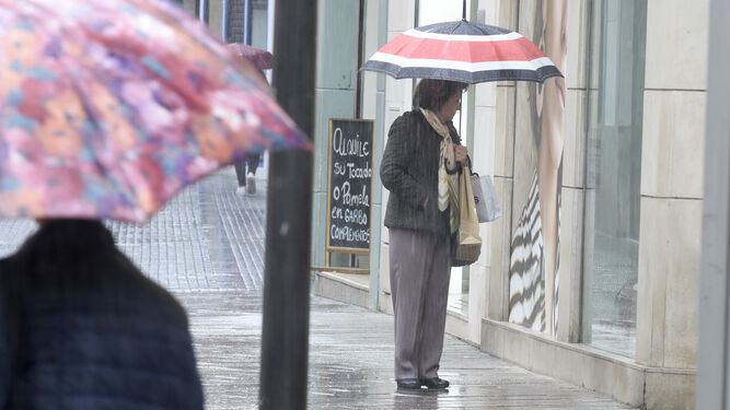 Una mujer se protege de la lluvia, en Córdoba.