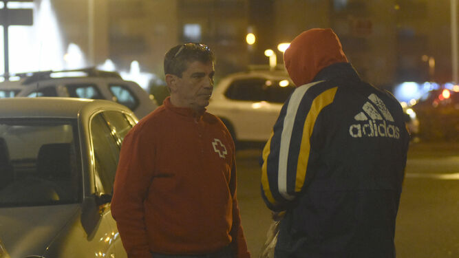 Un trabajador de Cruz Roja conversa con una personas sin hogar.