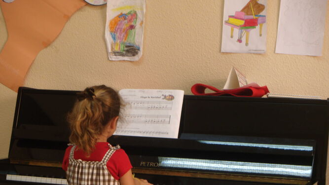 Una niña toca el piano en una clase de Música.