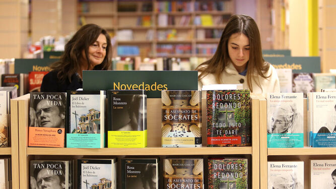 Dos mujeres observan títulos en una librería.