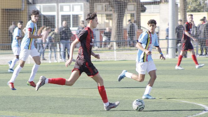 El jugador rojinegro Cerrato conduce el balón entre varios jugadores del Sporting de Ceuta.