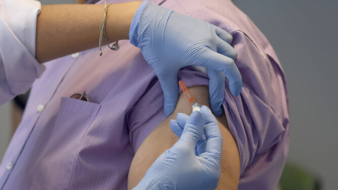 Una enfermera administra una vacuna de la gripe a un paciente.