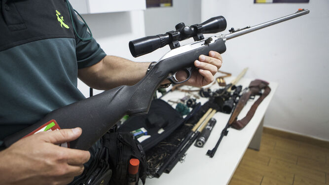 Un guardia civil muestra el rifle de un cazador furtivo.