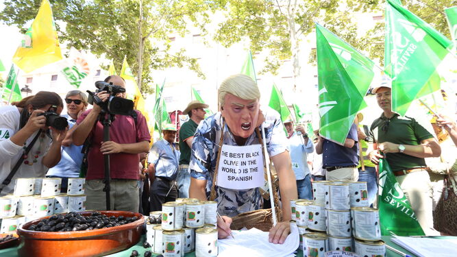 Un falso Donald Trump firma un manifiesto en defensa de la aceituna negra durante una protesta en Sevilla.