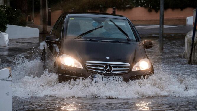 Un coche transita una calle inundada de Cala de Bou (Ibiza)