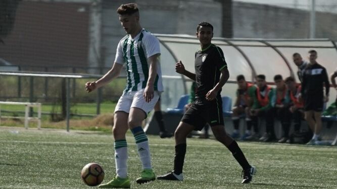 Un jugador blanquiverde controla el balón en presencia de un rival del Vázquez Cultural.