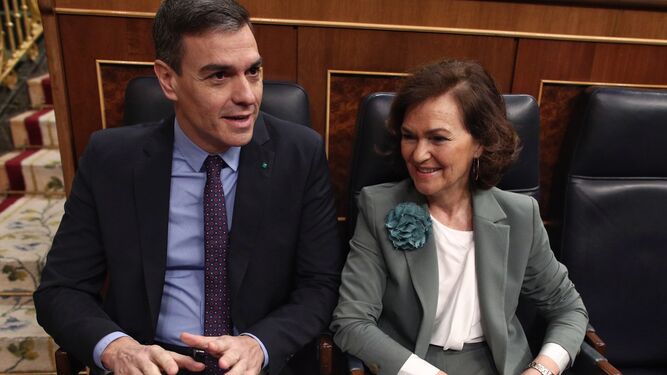 Pedro Sánchez y Carmen Calvo conversan en sus escaños del Congreso.