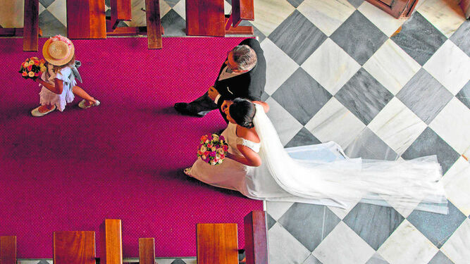 Una mujer entra vestida de novia en una iglesia antes de contraer matrimonio.