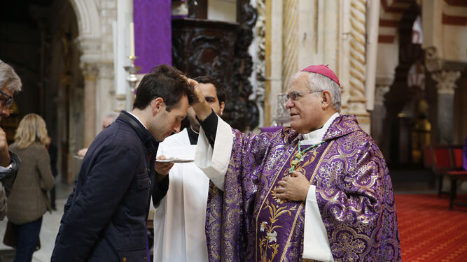 El obispo, Demetrio Fernández, impone la ceniza a un hombre en la Mezquita-Catedral.