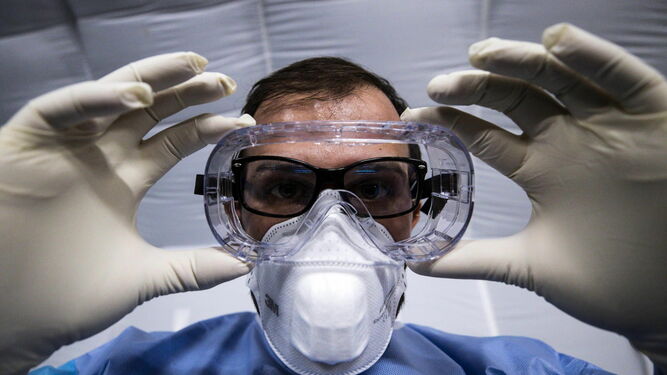 Un sanitario se coloca unas gafas de seguridad