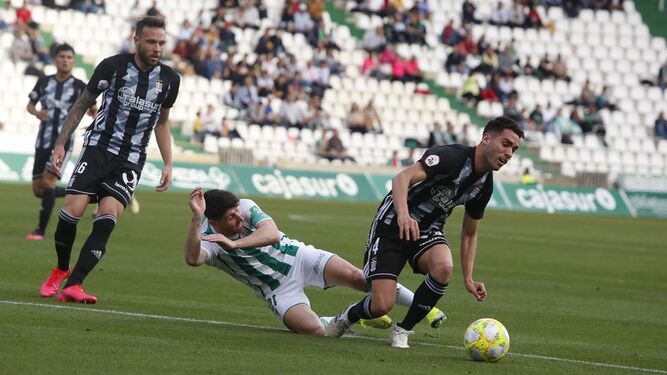 Javi Flores cae al suelo entre dos jugadores del Cartagena.