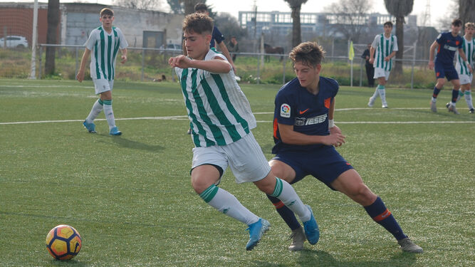El juvenil blanquiverde Cantarero escapa de la presión de un jugador del Málaga.