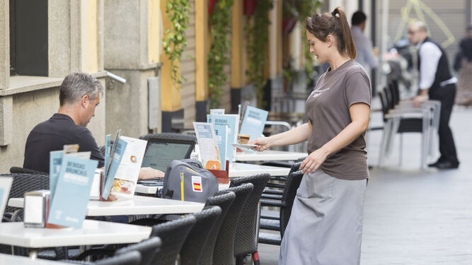 Una camarera atiende a los clientes en una terraza de Córdoba.