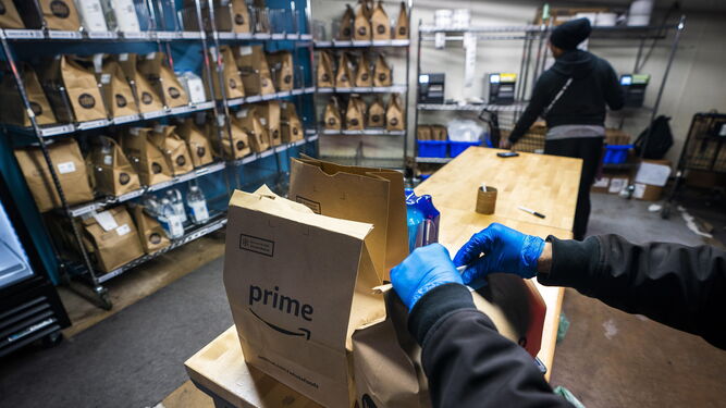 Un empleado de Amazon prepara varios paquetes.