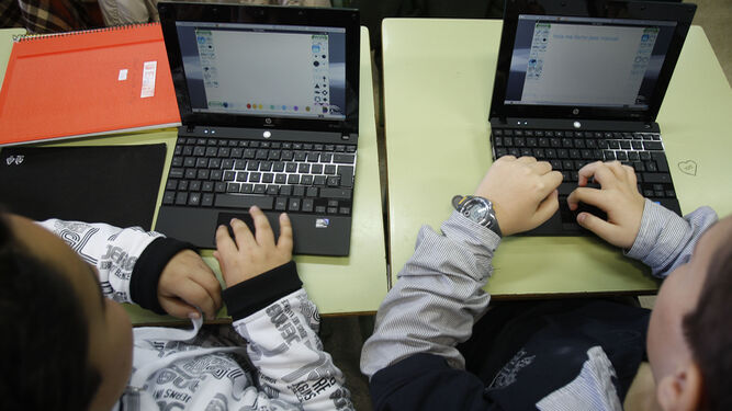 Alumnos con ordenadores portátiles en las aulas.