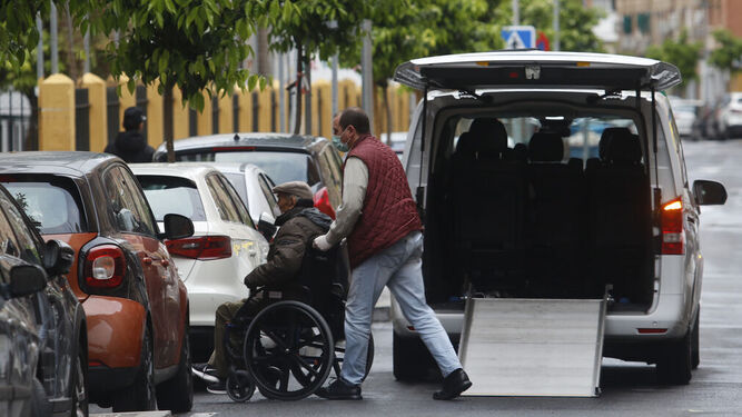 Un hombre atiende a una persona mayor durante la alerta sanitaria en Córdoba.