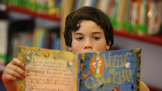 Un niño hojea un libro en una librería.