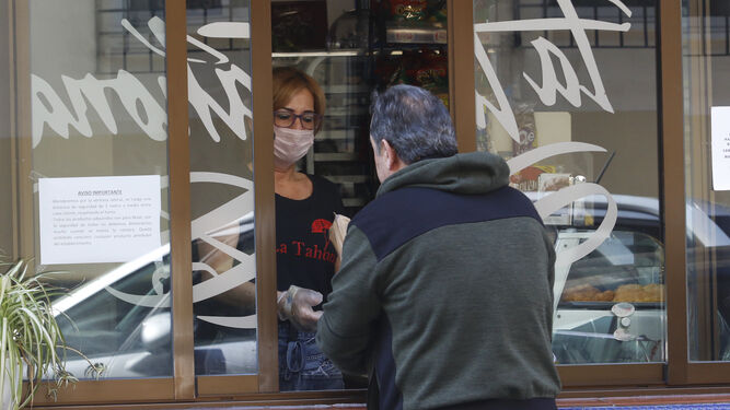 Una mujer atiende a un cliente en una tienda.
