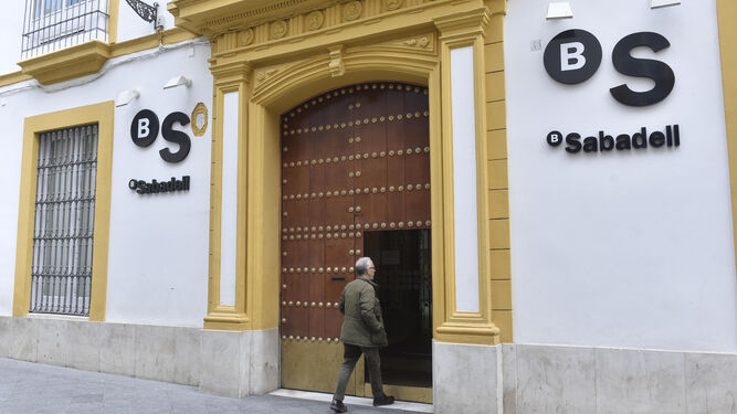 Un cliente entra en la oficina principal del banco Sabadell en Sevilla.