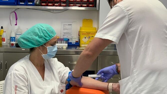 Un profesional del Hospital Cruz Roja hace el test a una compañera de la UCI.
