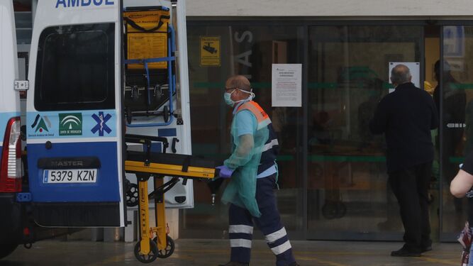 Un profesional de emergencias mete una camilla en una ambulancia.