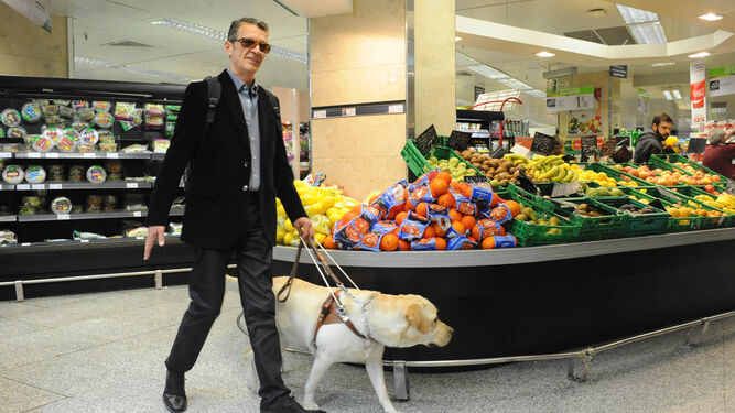 Una persona ciega con su perro guía en el supermercado