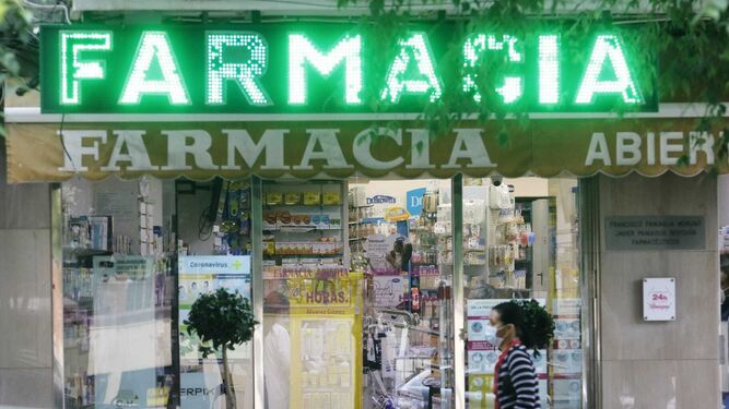 Una mujer pasa delante de una farmacia de la avenida Gran Vía Parque de Córdoba.