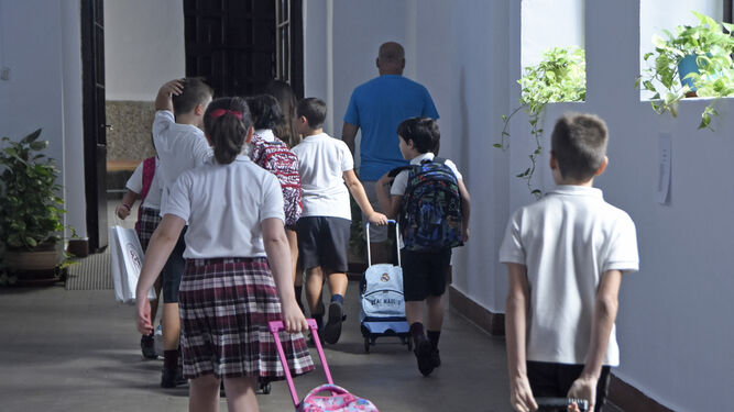 Un grupo de niños sale de clase con sus mochilas.