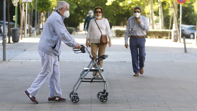 Un hombre se ayuda de un andador para caminar, en el primer día de paseo en Córdoba.