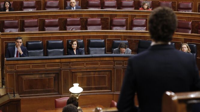 El presidente del Gobierno, Pedro Sánchez, escucha al líder de la oposición, Pablo Casado (de espaldas) durante el pleno de este miércoles en el Congreso.