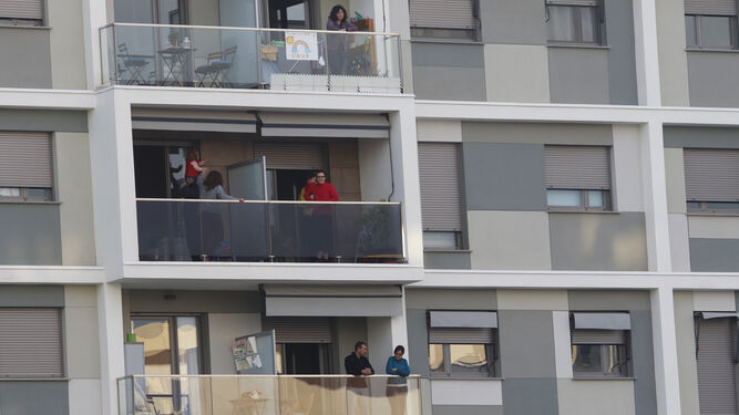 Varias personas, asomadas a sus balcones durante el periodo de confinamiento.