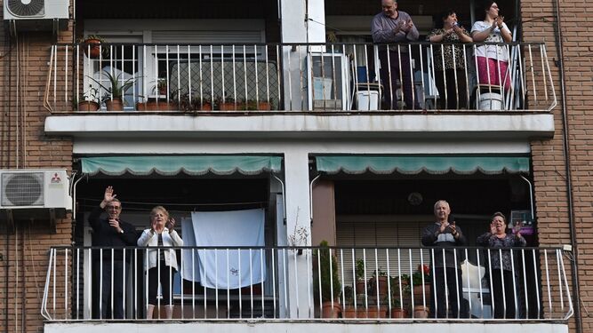 Unas familias aplauden desde el balcón