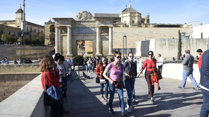 Un grupo de turistas circula por el Puente Romano